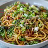 Steam rises from a hot bowl of Asian Teriyaki Noodle Bowl featuring tender veggies and chopsticks ready for a quick, easy dinner.
