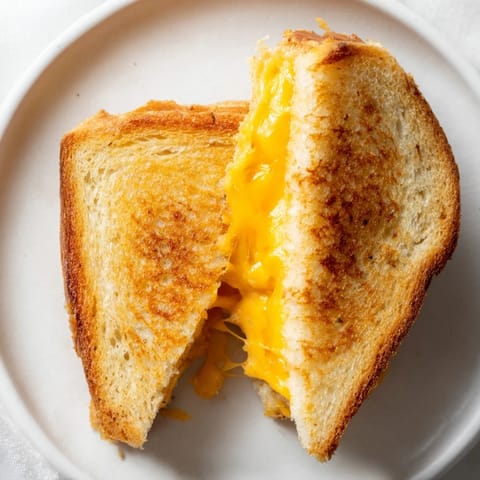 Close-up of a perfectly grilled Grilled Cheese Sandwich, showing crispy bread and gooey, delicious cheese.