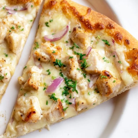 Golden, bubbly cheese and creamy Alfredo sauce cover tender chicken on this homemade Chicken Alfredo Pizza, with a crispy, golden-brown crust.  