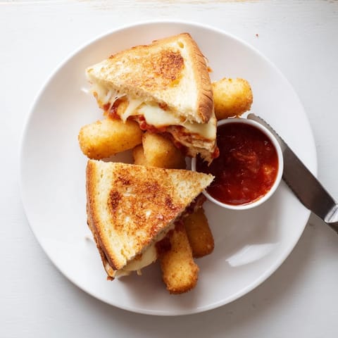 Golden toasted sourdough slices sandwich melted mozzarella and crispy fried sticks, served with a side of warm marinara dipping sauce.  