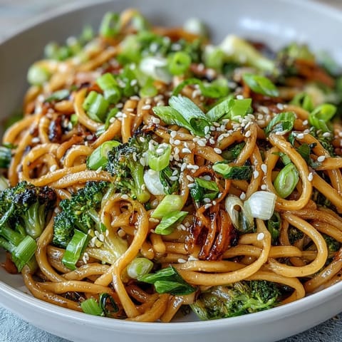Steam rises from a hot bowl of Asian Teriyaki Noodle Bowl featuring tender veggies and chopsticks ready for a quick, easy dinner.