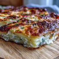 Golden, bubbling Cheese and Potato Pie fresh from the oven with melted Gruyère and cheddar.